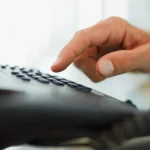 Une personne composant un numéro sur un téléphone
