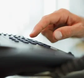 Une personne composant un numéro sur un téléphone