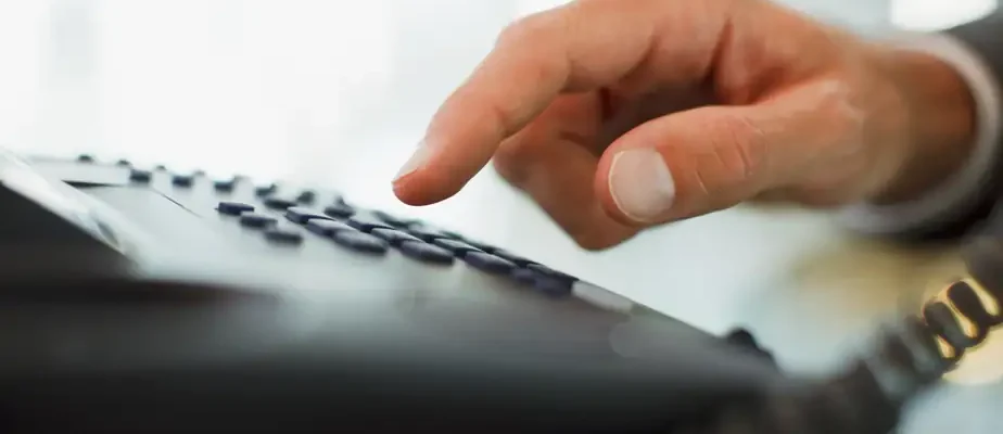 Une personne composant un numéro sur un téléphone
